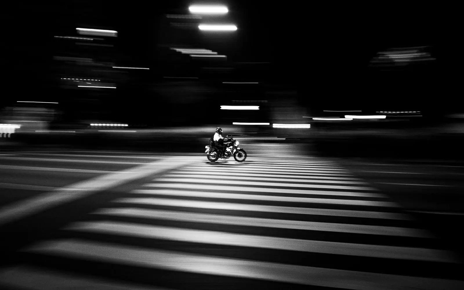 Moto cruzando una avenida de Buenos Aires de noche